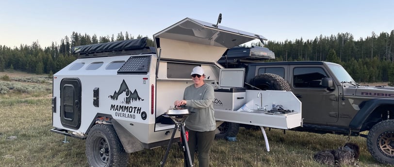 Emily sparks up a meal next to the Mammoth Overland HV