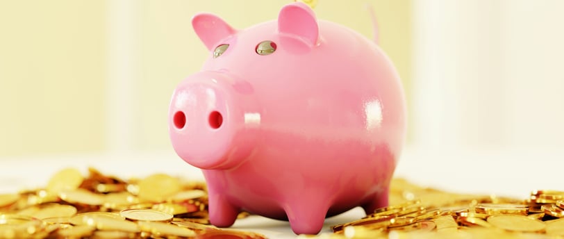 Porquinho de poupança rosa com moedas douradas, simbolizando economia e investimentos financeiros