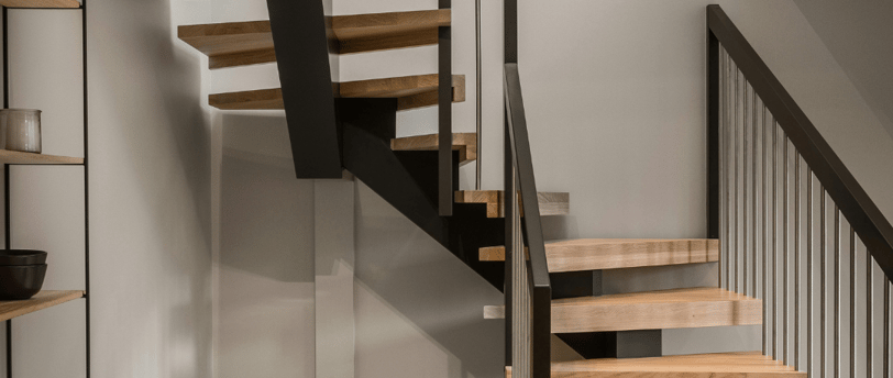 Escaleras modernas de madera y metal en una reforma integral en Valencia