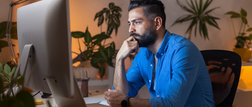 a man sitting at a desk with a laptop computer