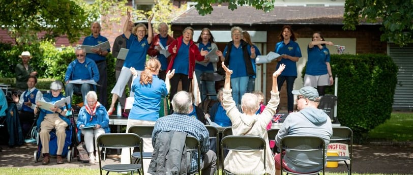 Choir singing on stage in park