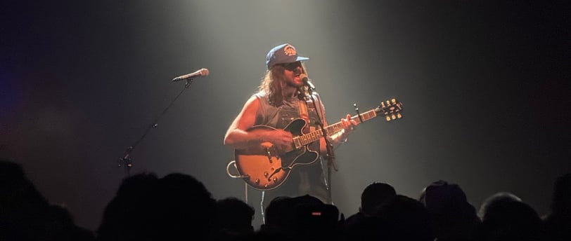 a man playing guitar in a concert