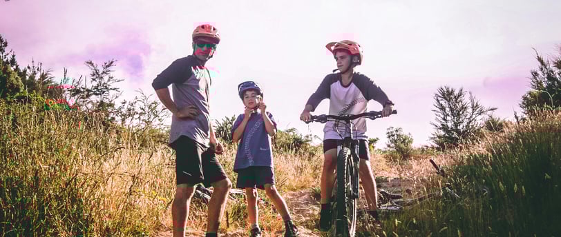 a man and two children on a mountain bike