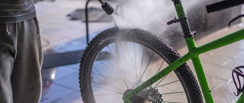 a man is using a spray gun to clean a bike