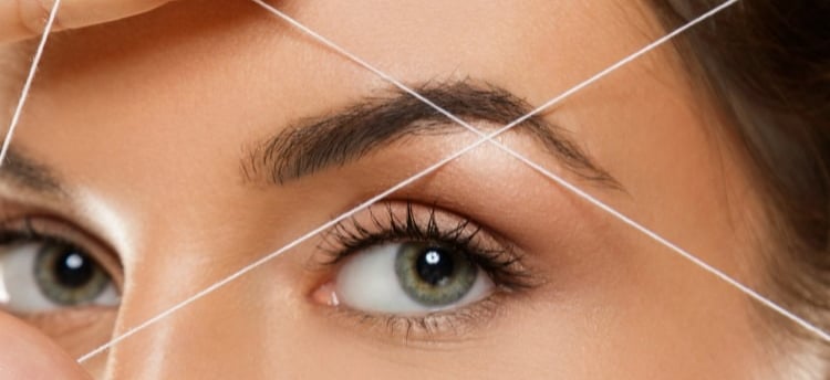 a woman with a thread threading on her forehead