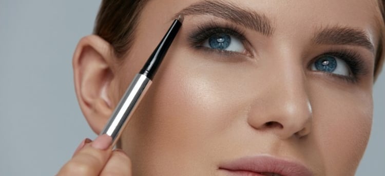 a woman with a black eyeliners and a mascara brush