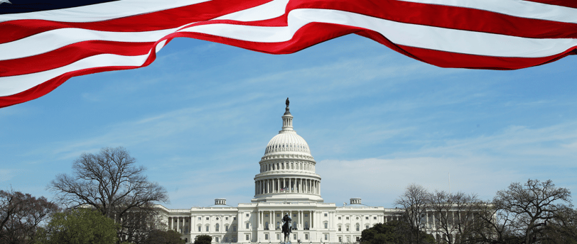 a flag flying in front of a large white building