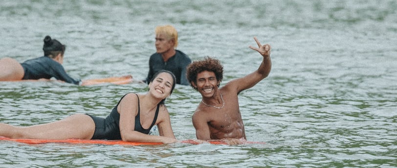 happy surfers in the water