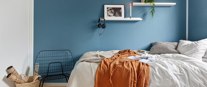 Floating shelves in a bedroom showcasing books and decor.