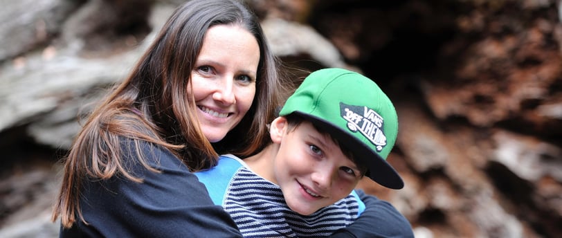a woman and a boy are smiling and hugging