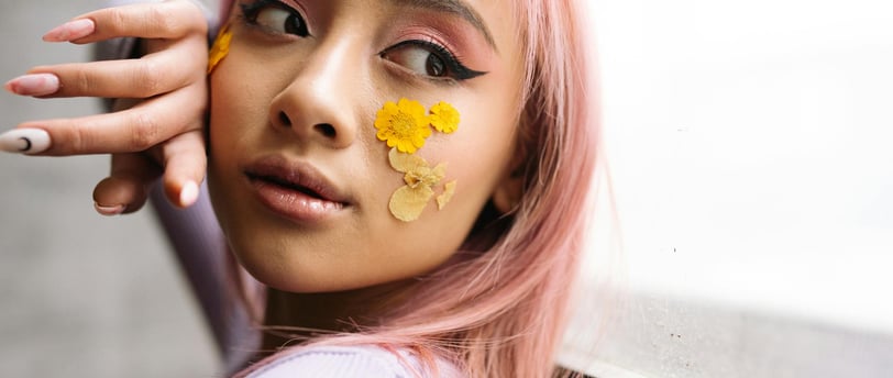 a woman with pink hair and yellow flowers on her face