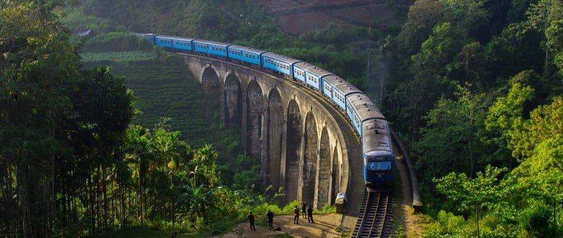 The iconic Nine Arch Bridge in Ella with a train passing through lush greenery