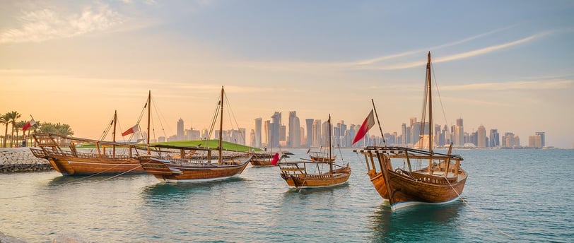 a group of boats in the water near a city