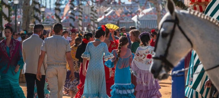 Feria de Abril in Sevilla, a group of people in colorful dresses and hats
