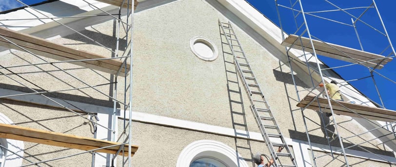 elastomeric paint being applied to a stucco building