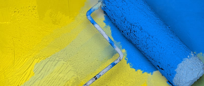 blue paint roller on yellow wall