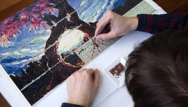 femme en train de faire du diamond painting