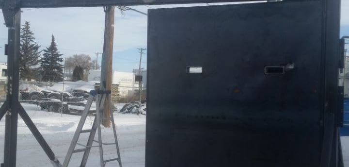 a black metal gate with a ladder and a ladder