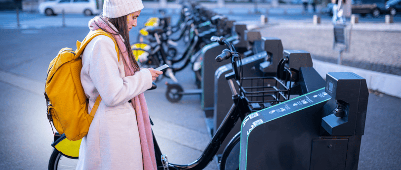 jovem aciona smartphone para alugar bicicleta