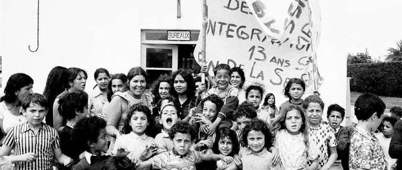 a group of children and adults standing in front of a building