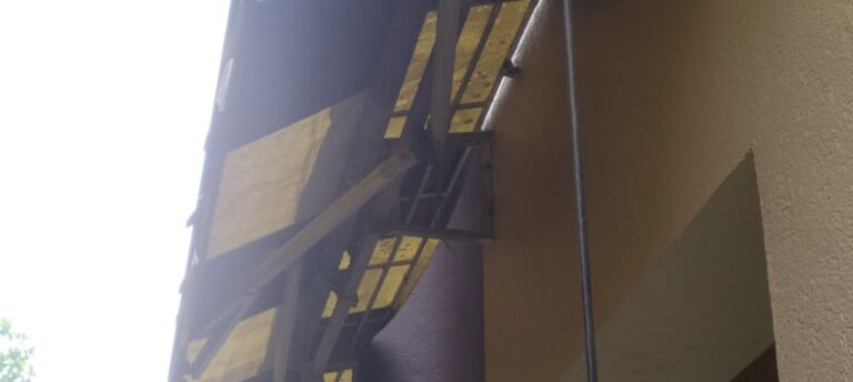 a yellow and black awning on a building repair