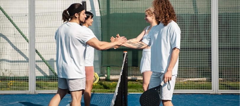 Padel Vibes blog post, padel players shaking hands on a padel court