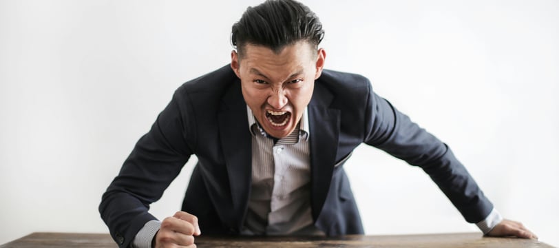 a man in a suit and tie is screaming at someone