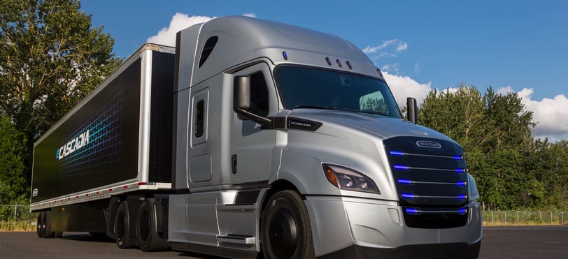 a semi truck with trees in the background