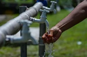 a person holding a hosepipe with water coming out of it