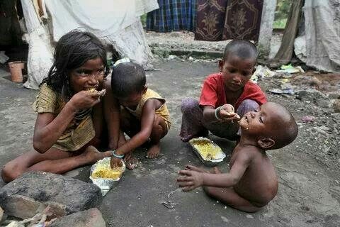 a group of children eating food in a makeshift shelter in Africa