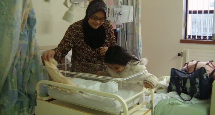Doula Jannah with her 3rd born baby and her first born baby looking on to the baby. All ready to be 