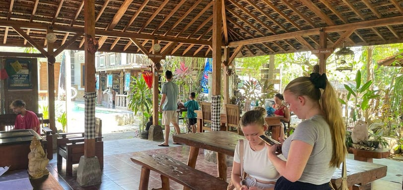 a group of people sitting at a table with a cell phone going for 7 days 6 nights Sunrise bali tours
