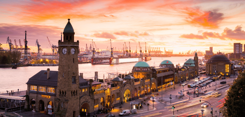 Ein Uhrenturm in einer Stadt bei Sonnenuntergang.