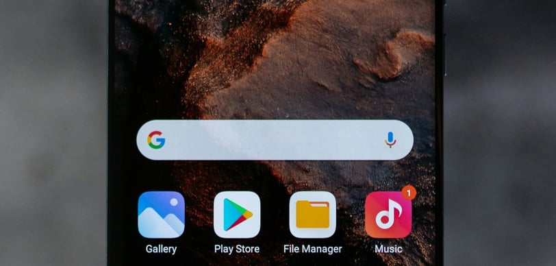 a close up of a smartphone with a phone in the background