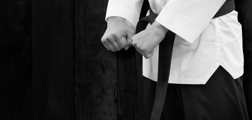 a man in a white shirt and black belt belt