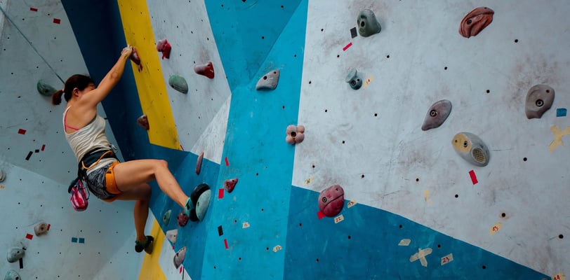 Woman bouldering in a climbing gym; Kobieta wspinająca się w boulderowni