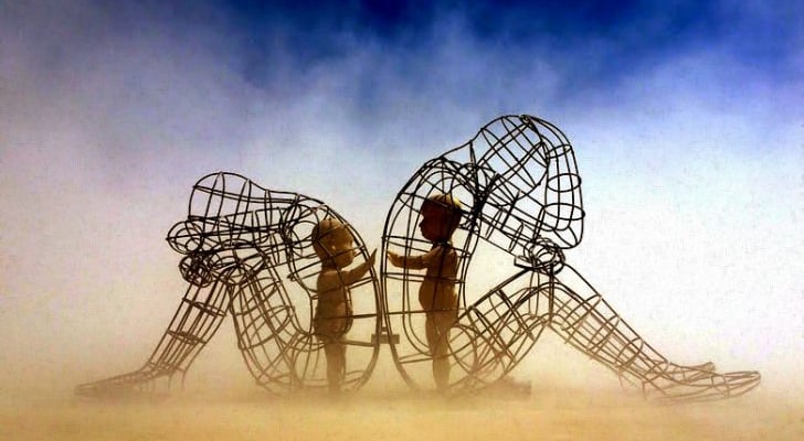 a group of people standing around a sculpture