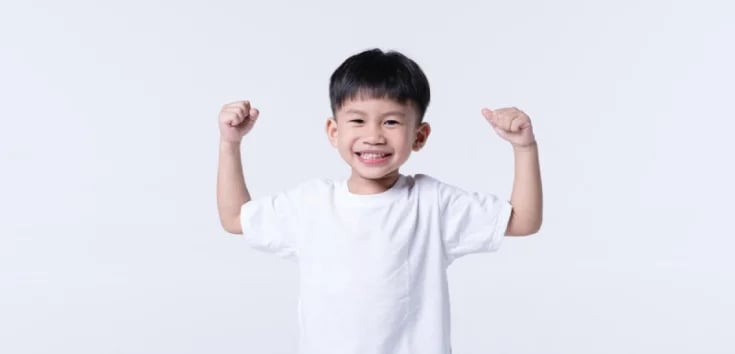 seorang anak berbaju outih dengan senyum yang menandakan kondisi yang sehat dan kuat
