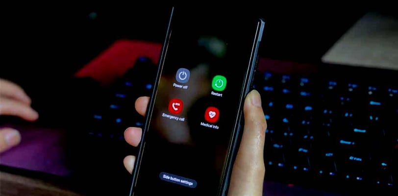a person holding a phone in their hand, reboot