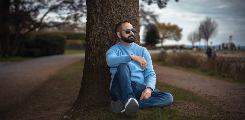 a man with a beard and sunglasses sitting on the ground