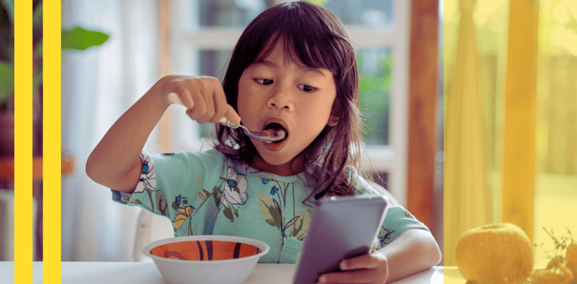 a young girl eating a bowl of soup with a spoon