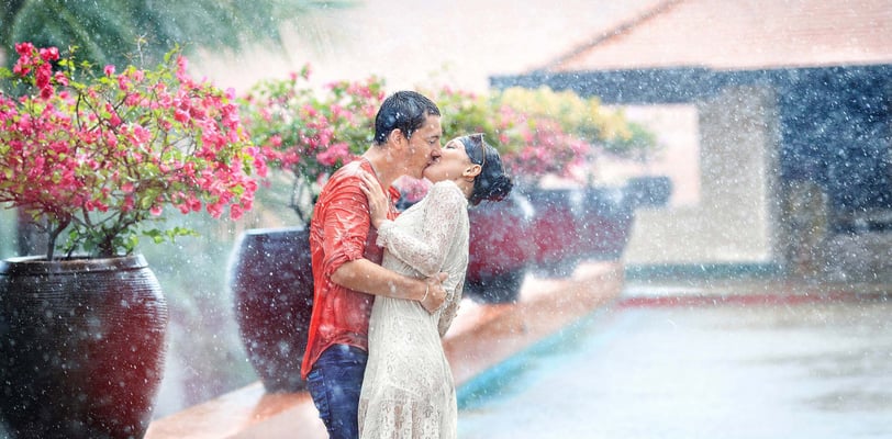 Young couple in love, guy and girl, Europeans, kiss in the rain on Koh Samui, Thailand
