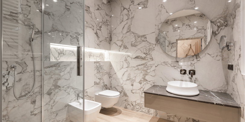 Baño moderno reformado en Valencia con acabados elegantes y grifería eficiente.