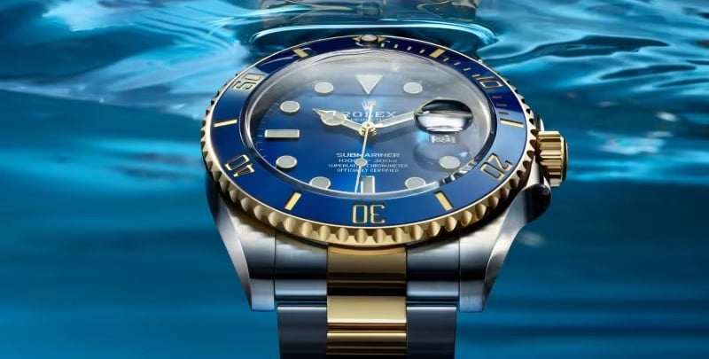 Rolex Submariner with a blue dial and gold accents, showcasing luxury and precision.