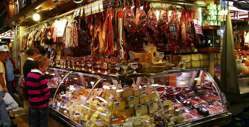 Market stall in Barcelona selling a variety of cheeses and meats