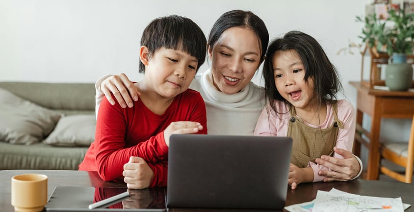 a woman and two children sitting at a table