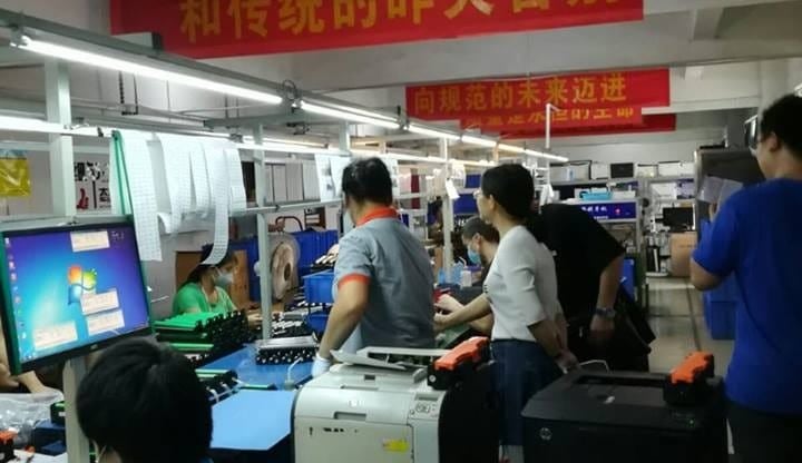 a group of people standing around a computer desk