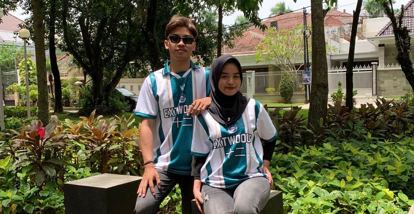 a man and woman sitting on a bench in a park