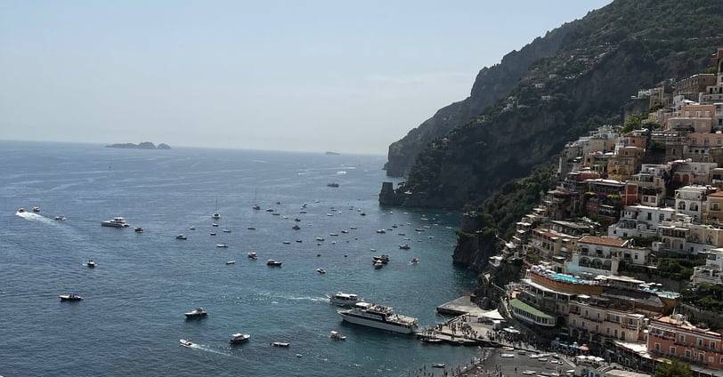 paisagem com barcos ao mar e encosta com casas