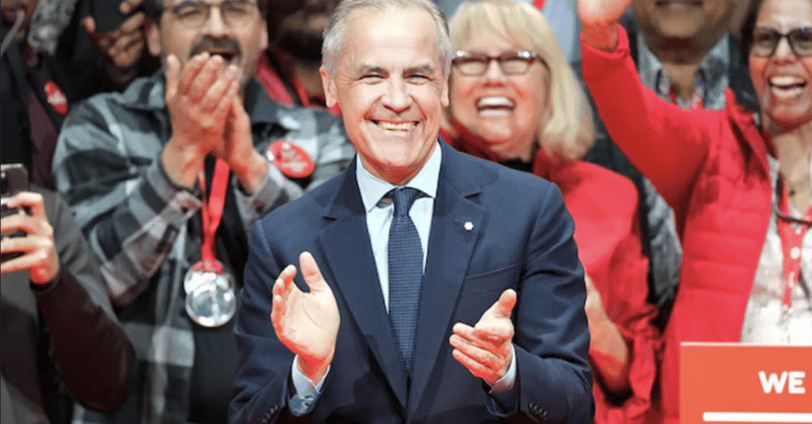 a man in a suit and tie is standing in front of a crowd of people